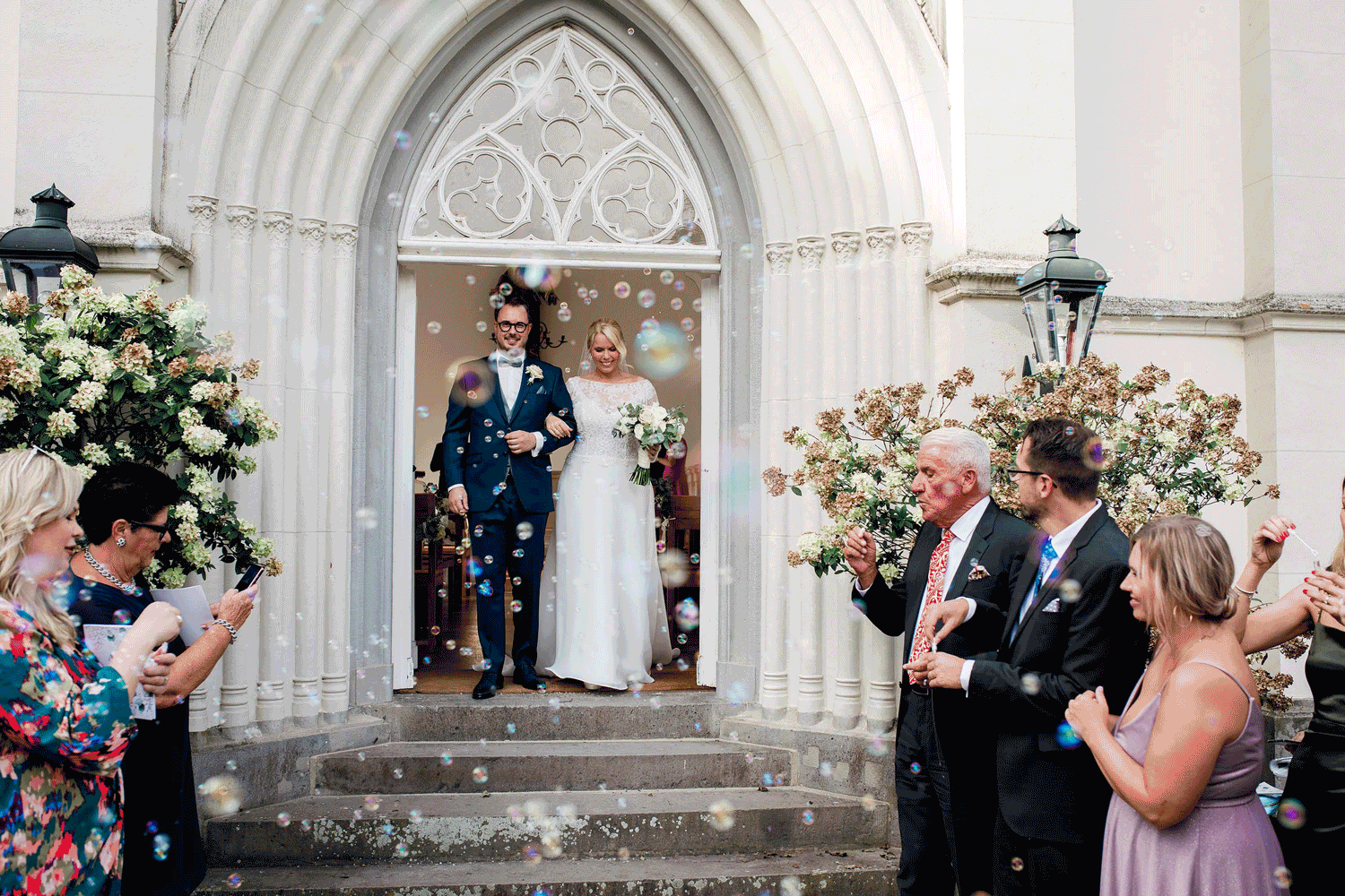 freudiges Brautpaar beim Auszug nach der Kirche